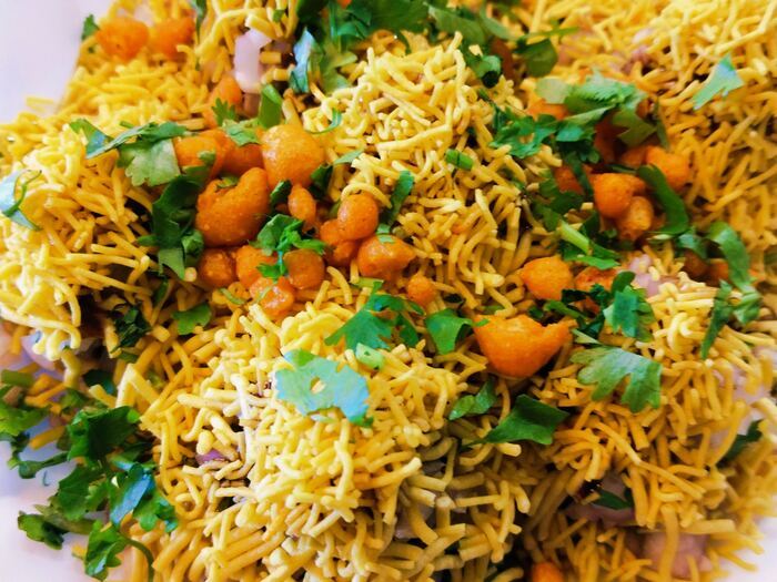 Sev puri chaat piled high with sev, onion and coriander