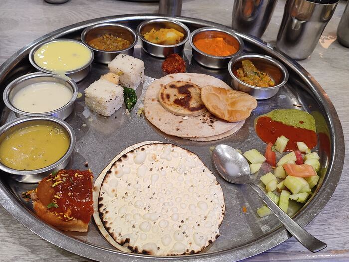 A full Gujarati thali platter with dal, curries, roti and rice
